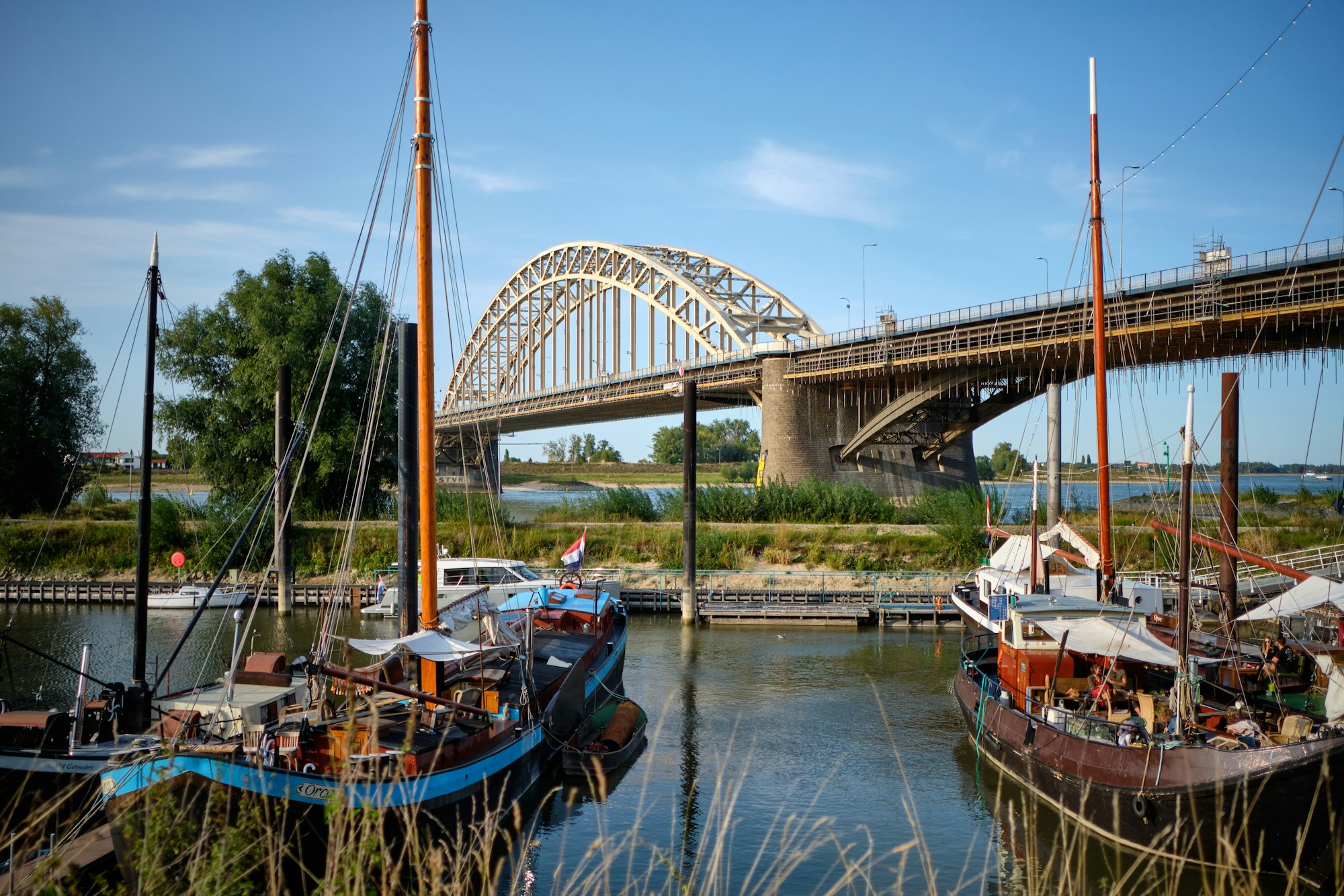 view of the harbor with beautiful ships and Waalbrug bridge in the background in the Netherlands